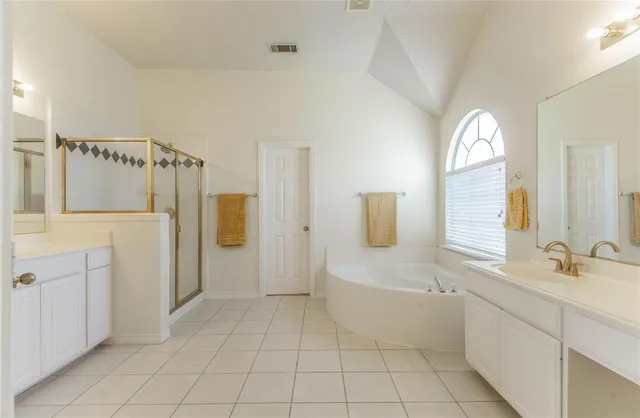 a spacious bathroom with a mirror a sink and a shower