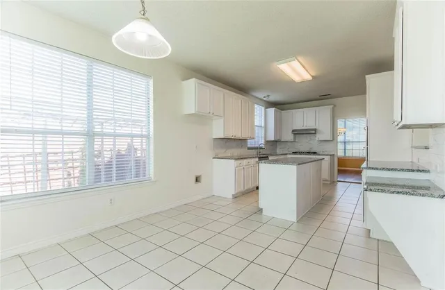 a kitchen with cabinets and window
