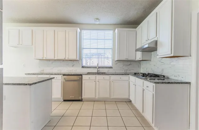 a kitchen with granite countertop white cabinets and white appliances