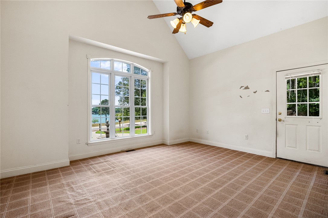 135 Sunset Bay Boulevard Seneca, SC 29672 - Photo 20 of 50 A spacious room with a vaulted ceiling and a wide arched window framing a beautiful water view.