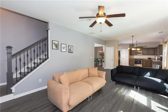 a living room with furniture and a ceiling fan