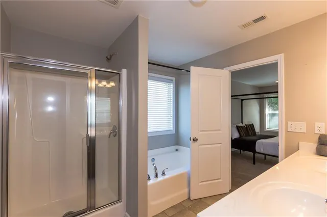 a spacious bathroom with a glass shower door and a bathtub