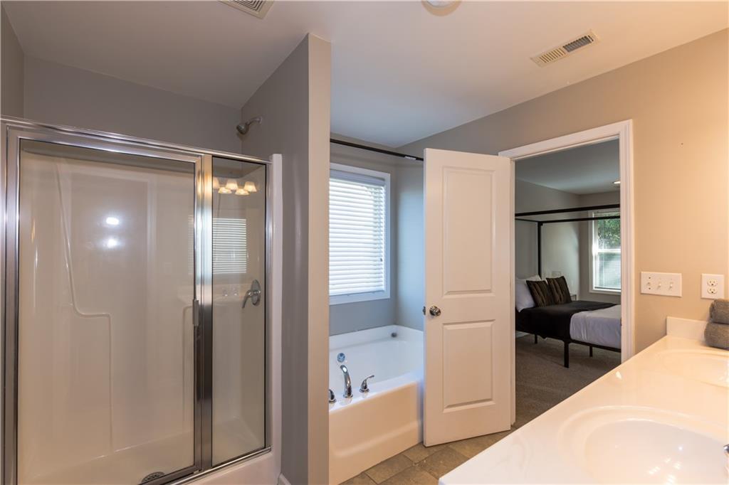 4245 Pear Haven Lane Gainesville, GA 30504 - Photo 26 of 39 a spacious bathroom with a glass shower door and a bathtub