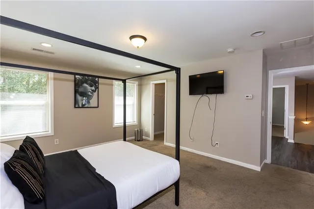 a bedroom with a bed and a flat screen tv