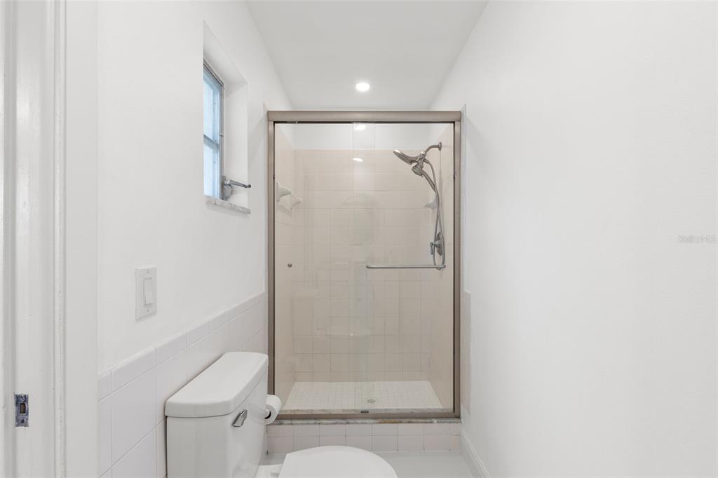 3488 Shady Bluff Drive Largo, FL 33770 - Photo 17 of 29 a bathroom with a glass shower door