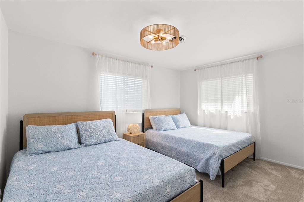 3488 Shady Bluff Drive Largo, FL 33770 - Photo 18 of 29 a bedroom with a bed and a chandelier