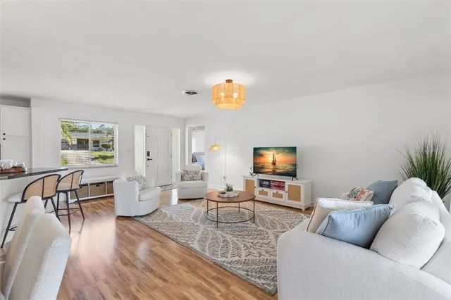 a living room with furniture wooden floor and a flat screen tv