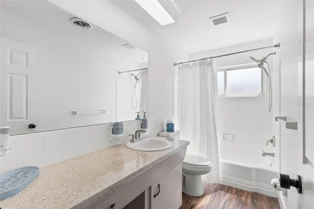a bathroom with a granite countertop sink toilet a shower and a mirror