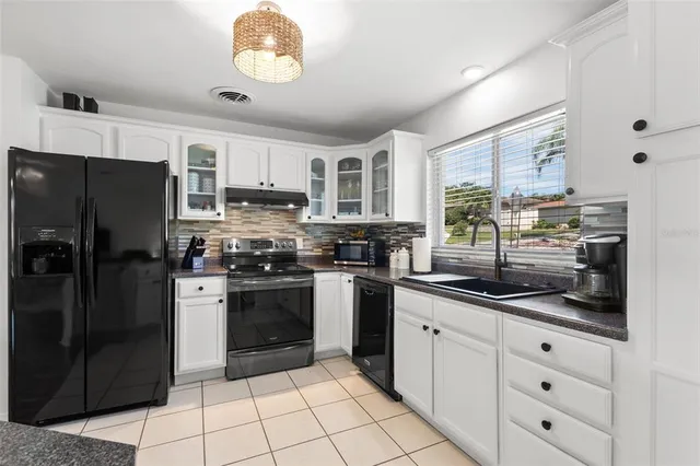 a kitchen with stainless steel appliances granite countertop a refrigerator and a stove top oven