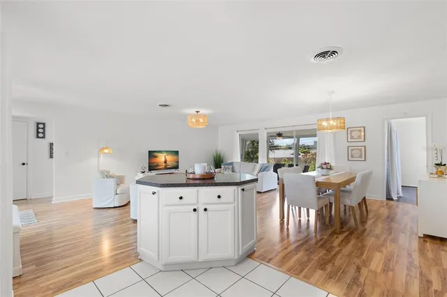 a kitchen with granite countertop a dining table chairs and white cabinets