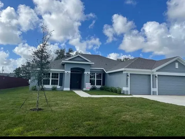 a view of a house with a yard and front view of a house