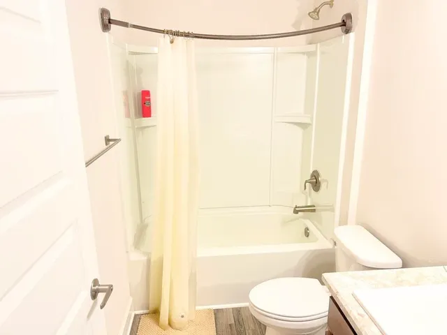 a white toilet sitting next to a bath tub