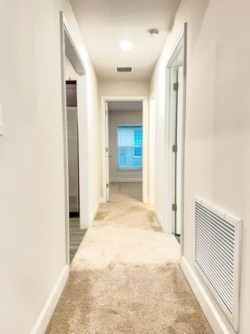 a view of a hallway with wooden floor and staircase