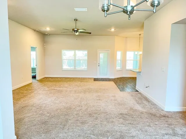 an empty room with a windows and ceiling fan