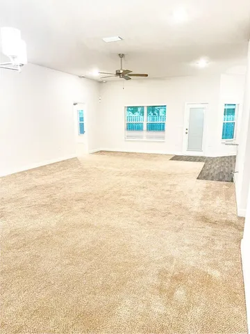 an empty room with kitchen appliances and windows