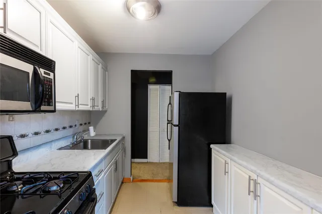 a kitchen that has a sink stainless steel appliances a counter space and cabinets