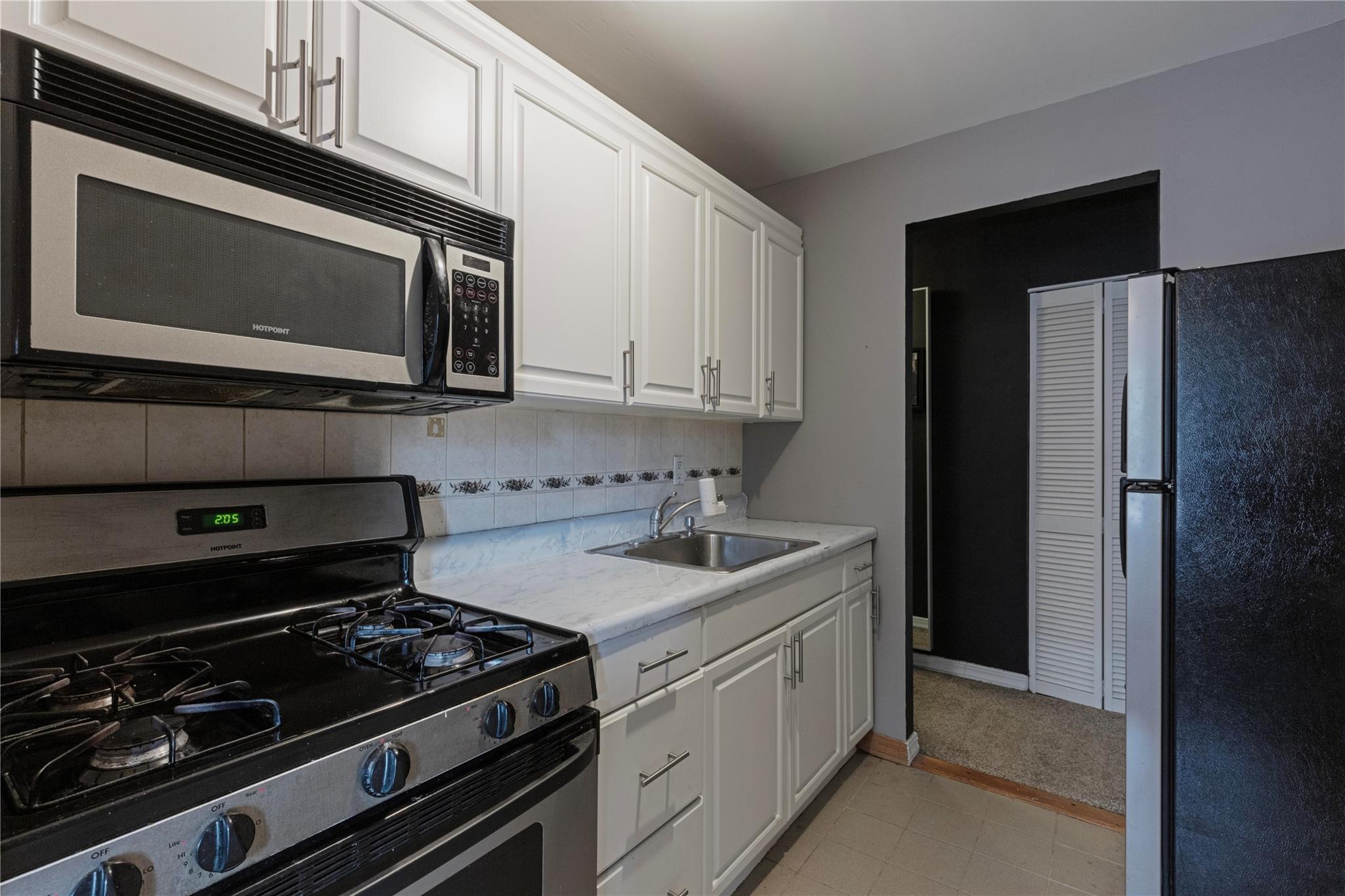 58-03 Calloway Street, Unit 3NN Queens, NY 11368 - Photo 15 of 23 a kitchen with stainless steel appliances a stove a microwave and cabinets