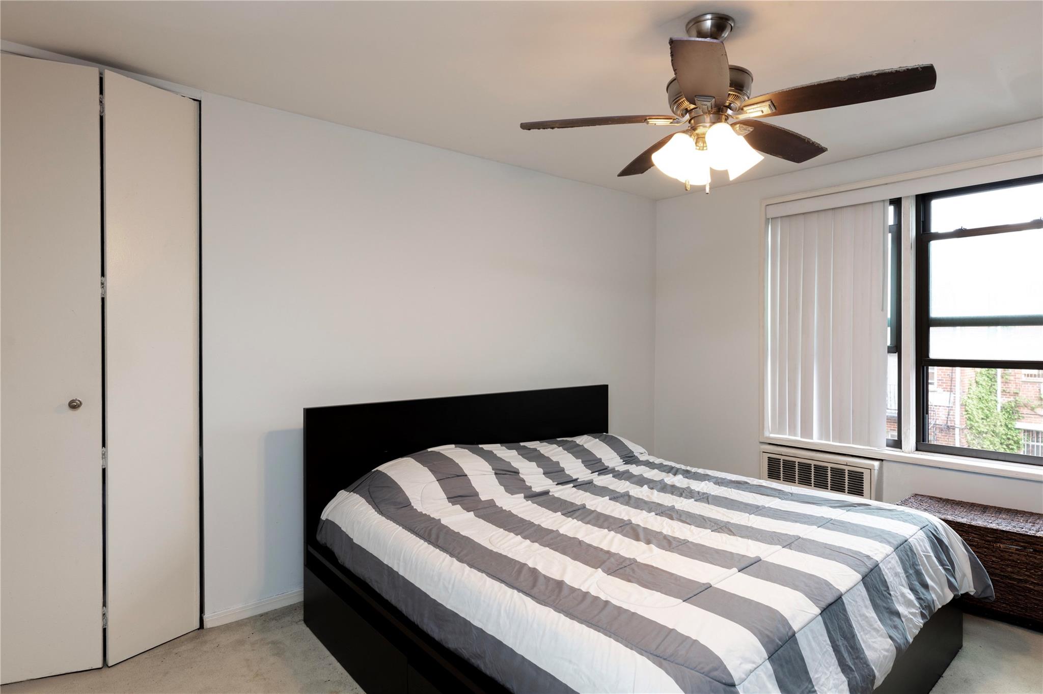 58-03 Calloway Street, Unit 3NN Queens, NY 11368 - Photo 16 of 23 a bedroom with a bed and a chandelier