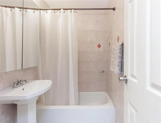 a bathroom with a sink a shower curtain and a mirror