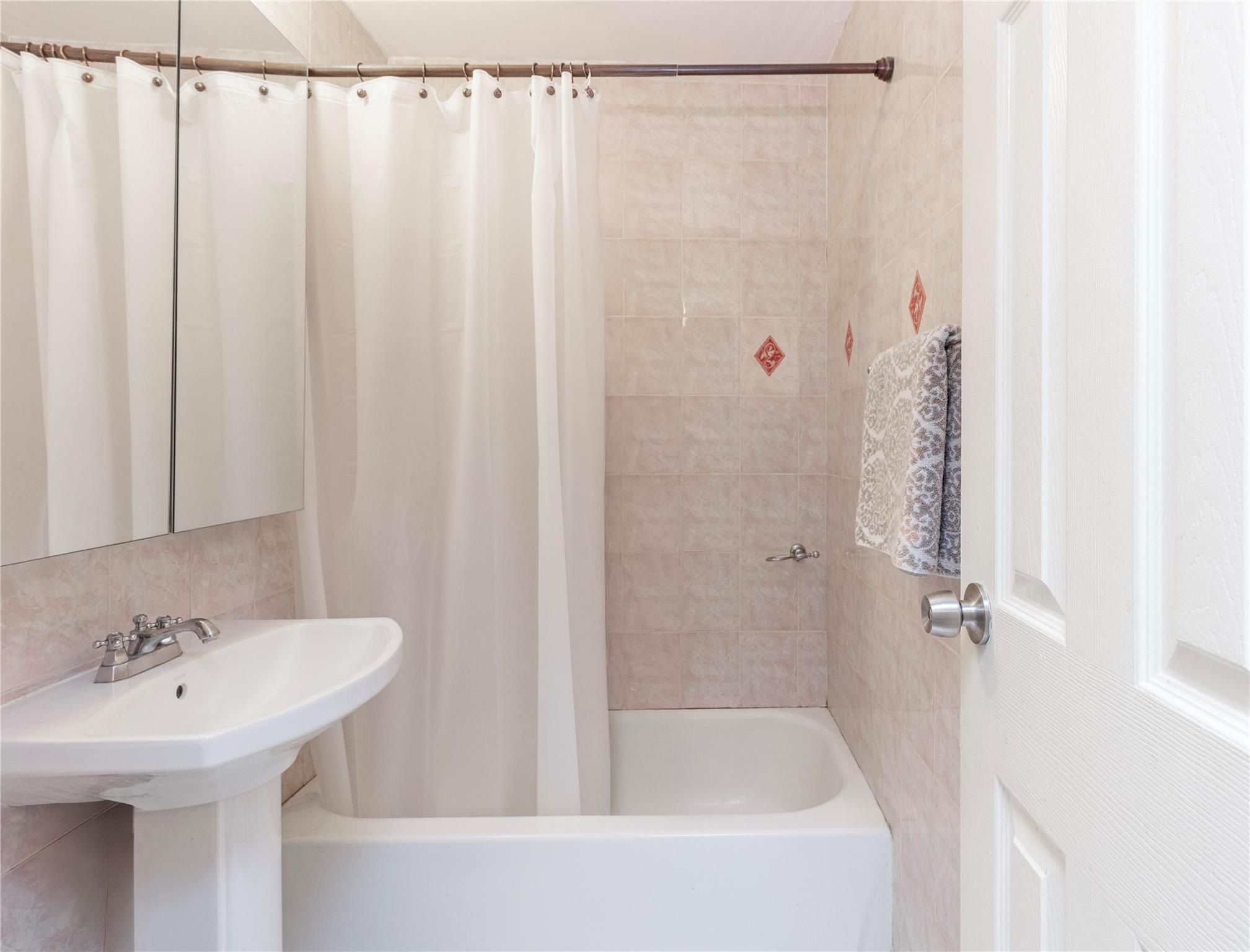 58-03 Calloway Street, Unit 3NN Queens, NY 11368 - Photo 20 of 23 a bathroom with a sink a shower curtain and a mirror