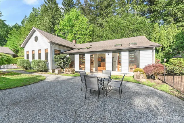 a view of a house with backyard and sitting area