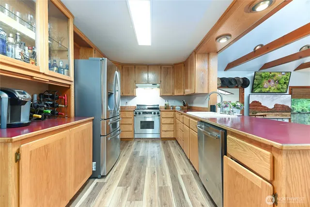 a kitchen with kitchen island granite countertop lots of counter top space and wooden floor