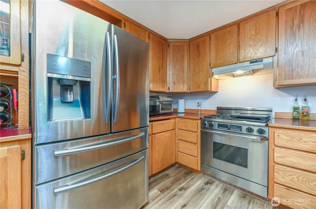 a kitchen with granite countertop stainless steel appliances and wooden cabinets