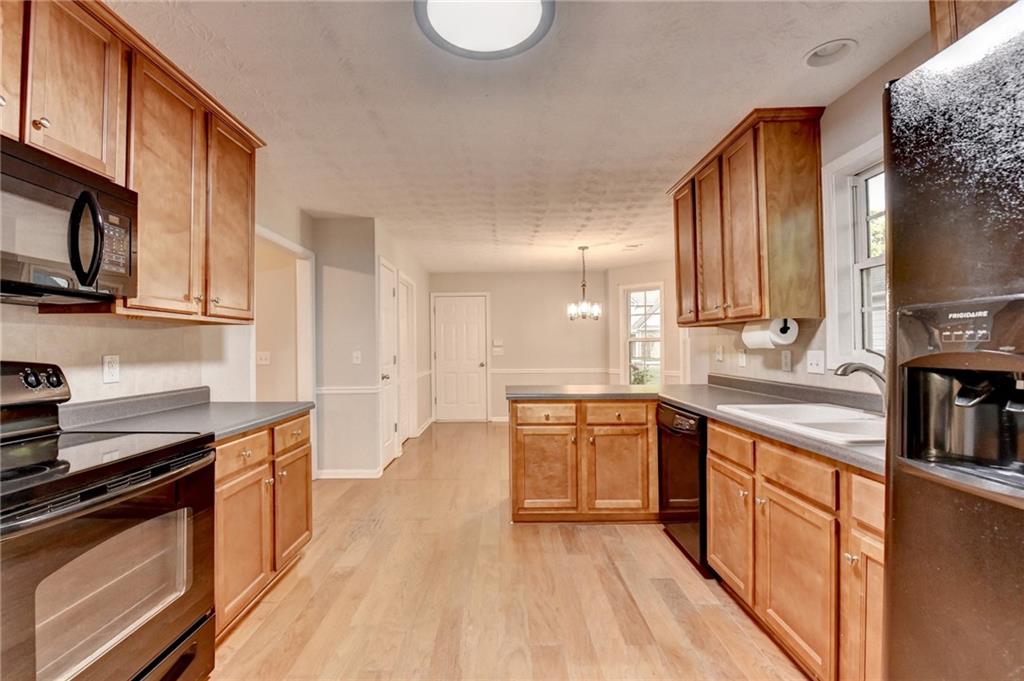 310 Andrew Ridge Drive Jefferson, GA 30549 - Photo 16 of 52 a large kitchen with stainless steel appliances granite countertop a stove a sink dishwasher and a microwave oven with wooden floor