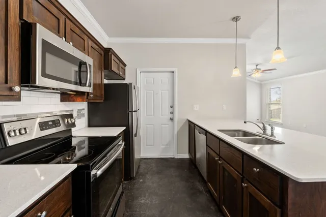 a kitchen with stainless steel appliances a refrigerator sink and microwave