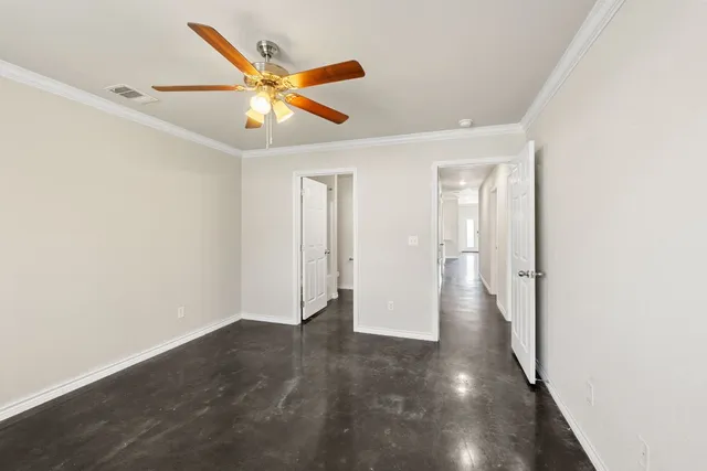an empty room with a ceiling fan and a window