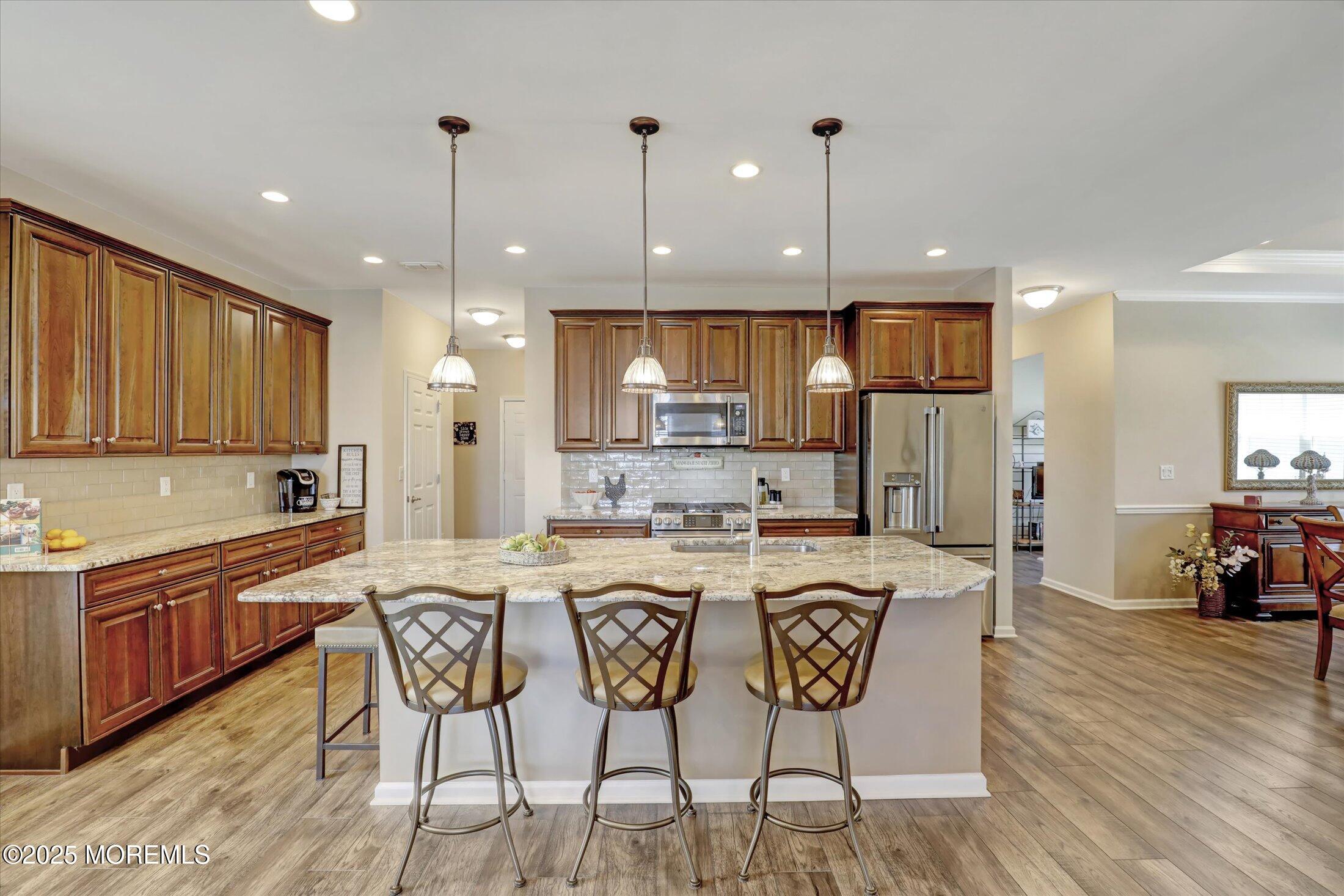 24 Moonlight Way Howell, NJ 07731 - Photo 11 of 34 a kitchen with stainless steel appliances granite countertop a kitchen island a stove a table and chairs