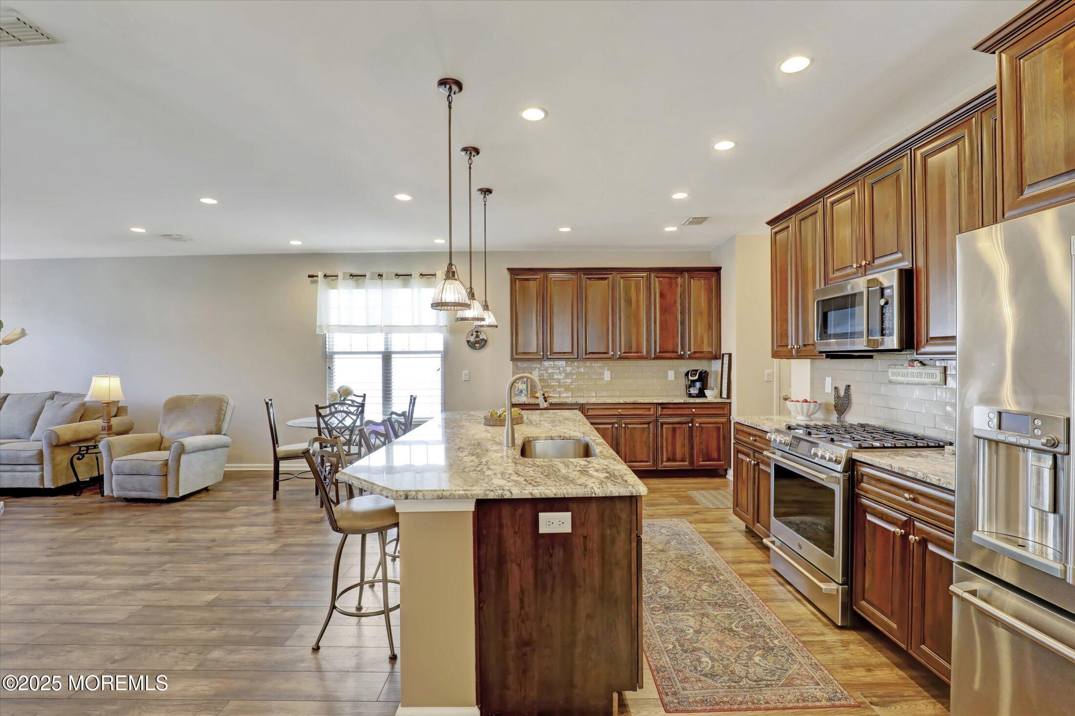 24 Moonlight Way Howell, NJ 07731 - Photo 14 of 34 a kitchen with stainless steel appliances granite countertop wooden cabinets sink dining table and chairs