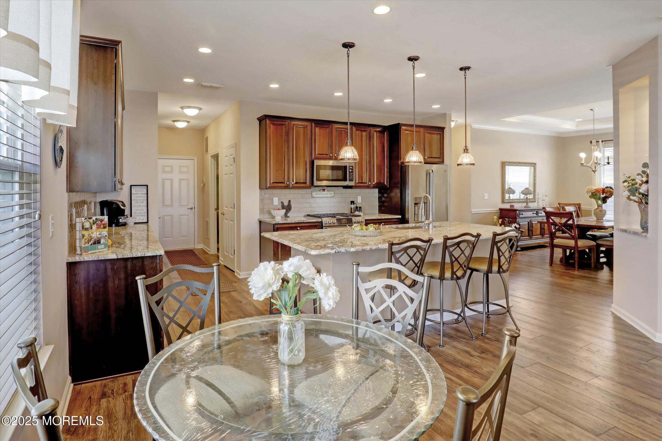 24 Moonlight Way Howell, NJ 07731 - Photo 10 of 34 a dining room with stainless steel appliances kitchen island granite countertop a table chairs and a living room view