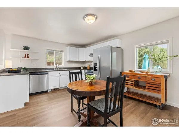 a kitchen with a table chairs a sink and dishwasher