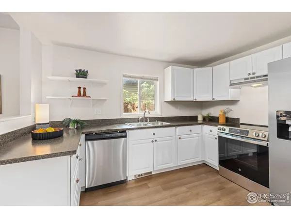 a kitchen with granite countertop a stove sink and cabinets