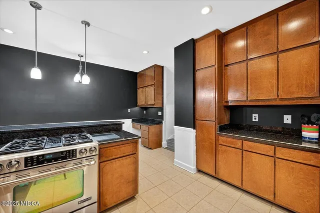 a kitchen with stainless steel appliances granite countertop a stove a sink and a refrigerator