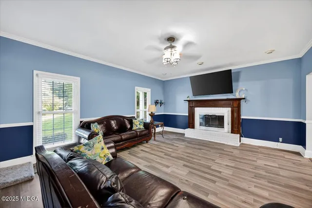 a living room with furniture a fireplace and a flat screen tv
