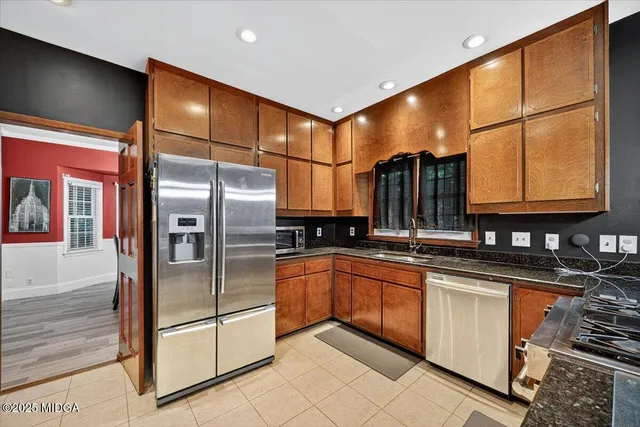 a kitchen with stainless steel appliances granite countertop a refrigerator a sink and a stove
