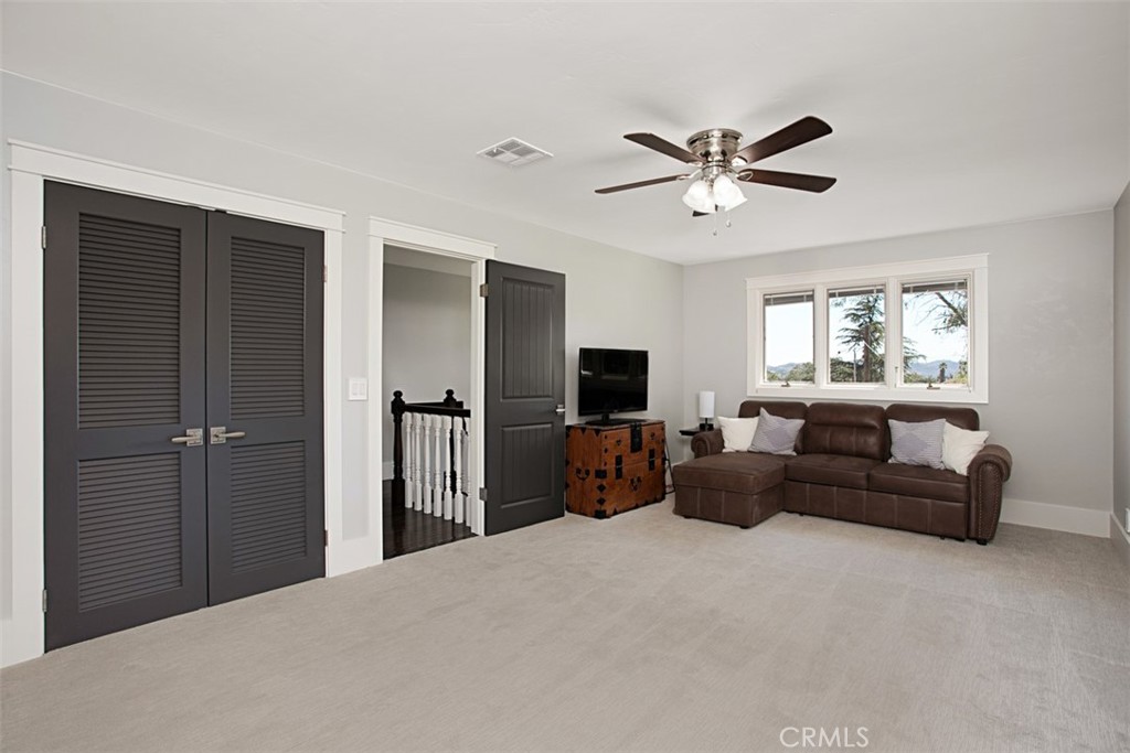 40791 Daily Road Fallbrook, CA 92028 - Photo 18 of 41 a living room with furniture a ceiling fan a flat screen tv and a window