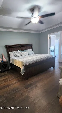 a bedroom with a bed and a flat tv screen on dresser