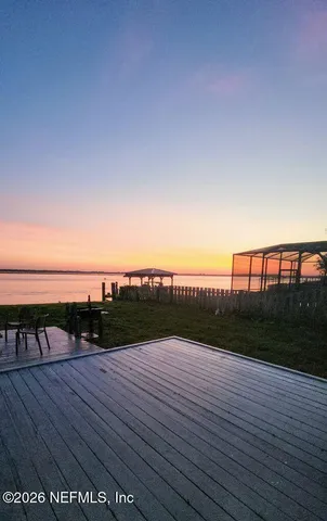 a view of a yard with wooden fence