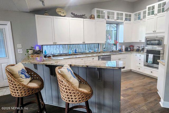 16039 Shellcracker Road Jacksonville, FL 32226 - Photo 10 of 39 a kitchen with stainless steel appliances granite countertop a table chairs sink and cabinets