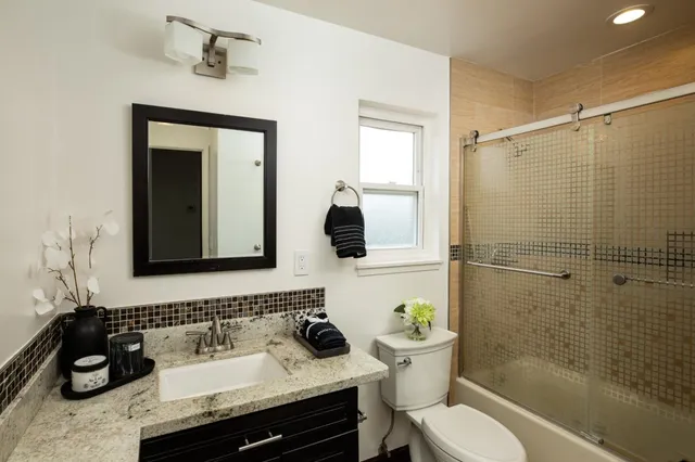 a bathroom with a sink toilet a mirror and shower