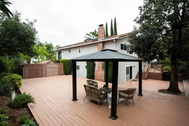 a view of a house with wooden deck and furniture