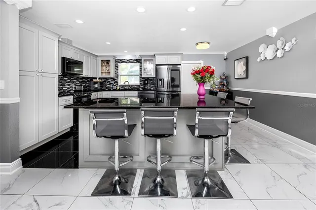 a white kitchen with stainless steel appliances and white cabinets