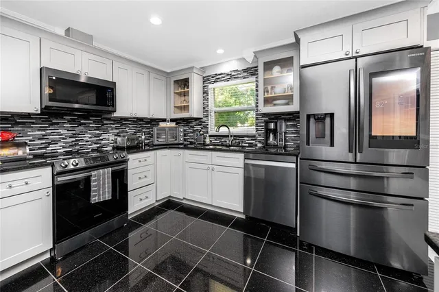 a bedroom with a large bed and a flat tv screen on dresser