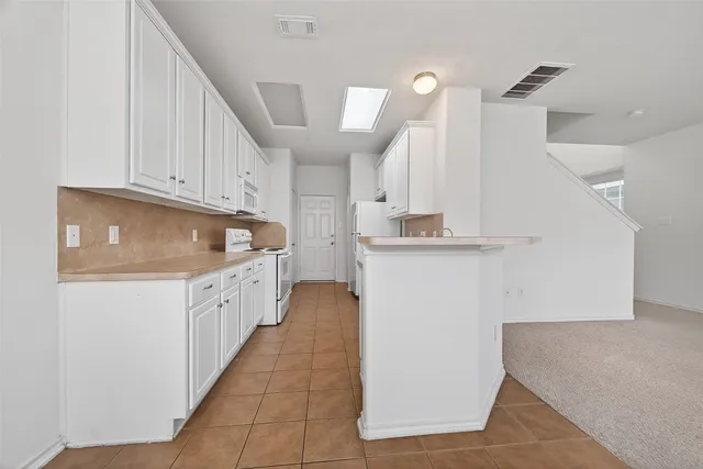 a kitchen with granite countertop a sink a stove top oven and cabinets