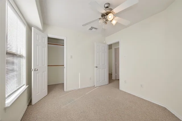 a view of a room with a ceiling fan and a window