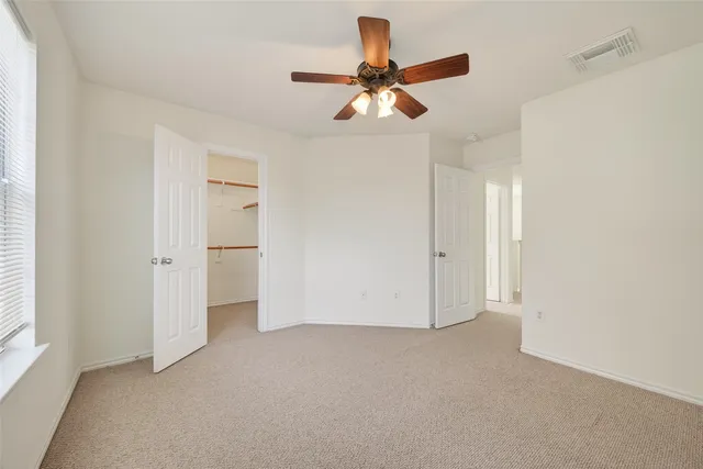 a view of an empty room and a ceiling fan