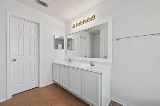 a bathroom with a double vanity sink and mirror